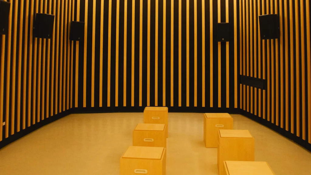 Fotografia della sala d'ascolto immersiva in ambiente con sedute e casse alle pareti e pareti insonorizzate.