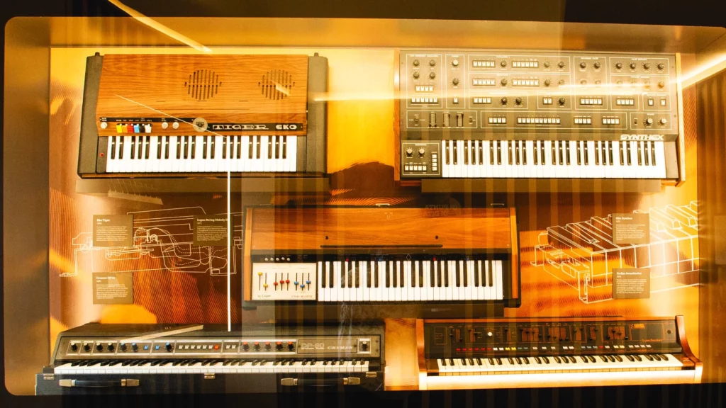 Fotografia di una teca con alcune tastiere EKO, ELKA, CRUMAR e FARFISA.